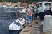 Izvlačenje potonule brodice u Komiži prije olujnog juga