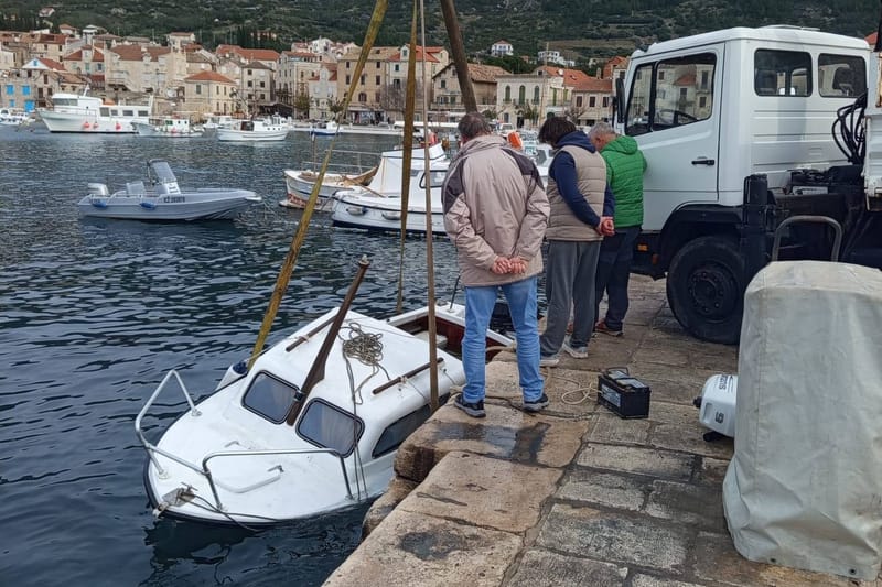 Izvlačenje potonule brodice u Komiži prije olujnog juga
