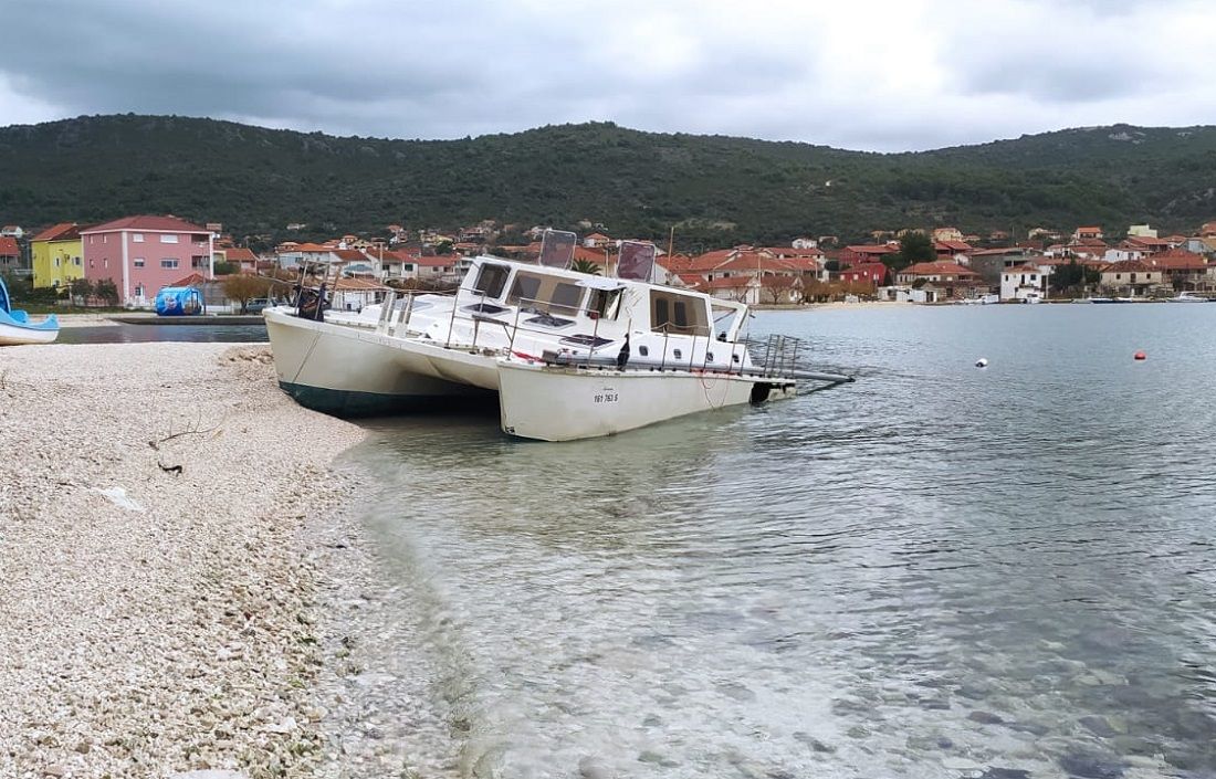 Katamaran već godinu dana nasukan na plažu u Vinišću: “Raspada se i prijeti onečišćenjem od goriva i maziva”